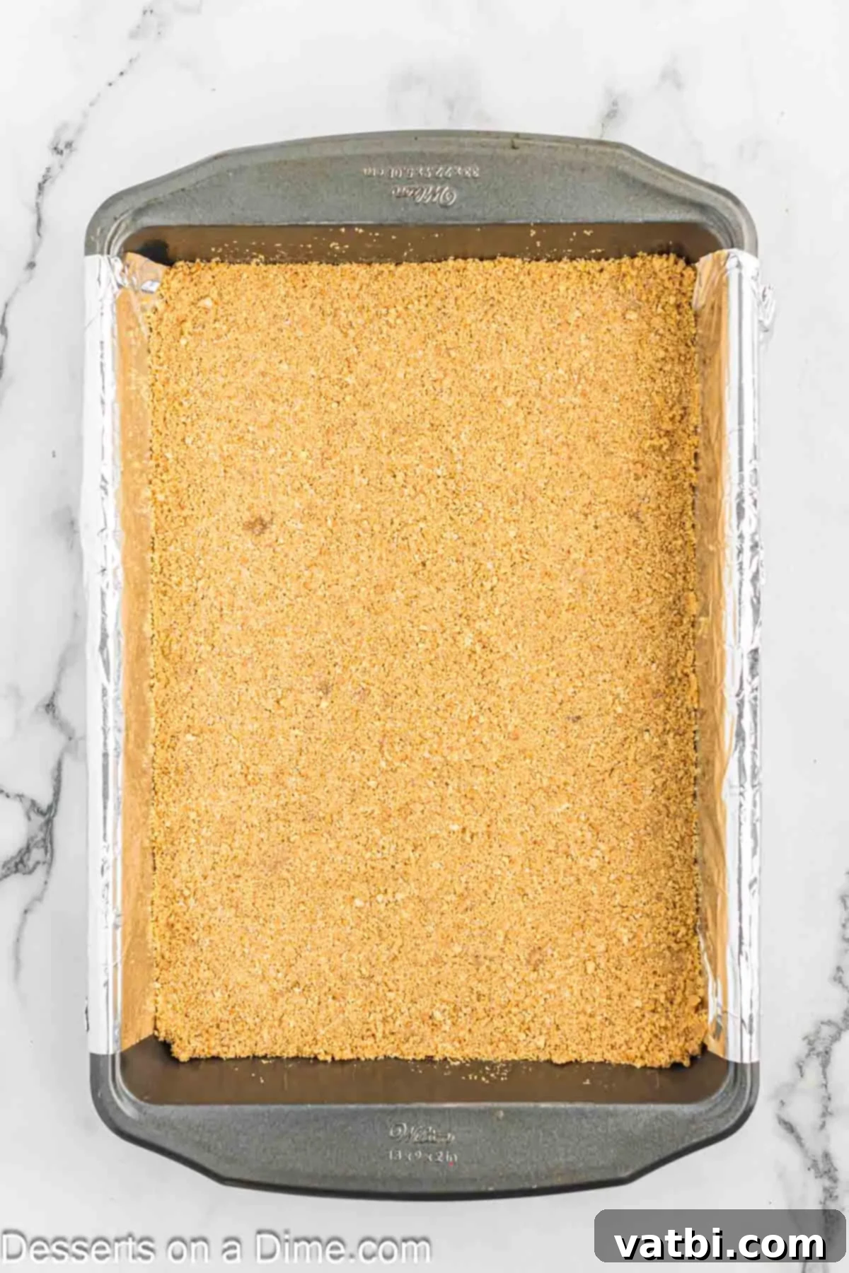 Gooey Smores Treat 5 Graham cracker crust evenly pressed into a baking dish, ready for baking.