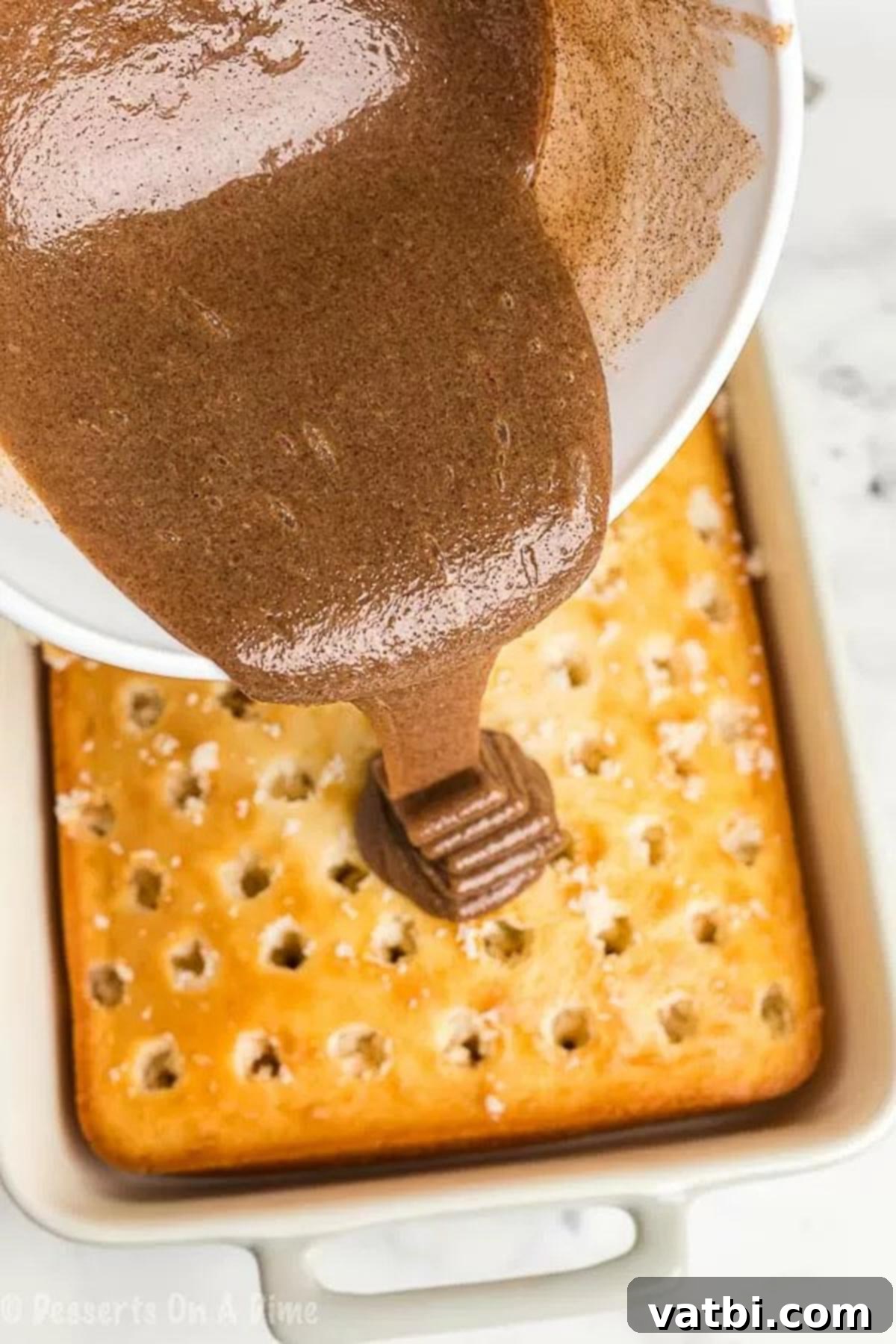 Irresistible Cinnamon Roll Poke Cake 4 The rich, gooey cinnamon mixture being generously poured over the warm, hole-poked cake, allowing it to seep into every crevice.
