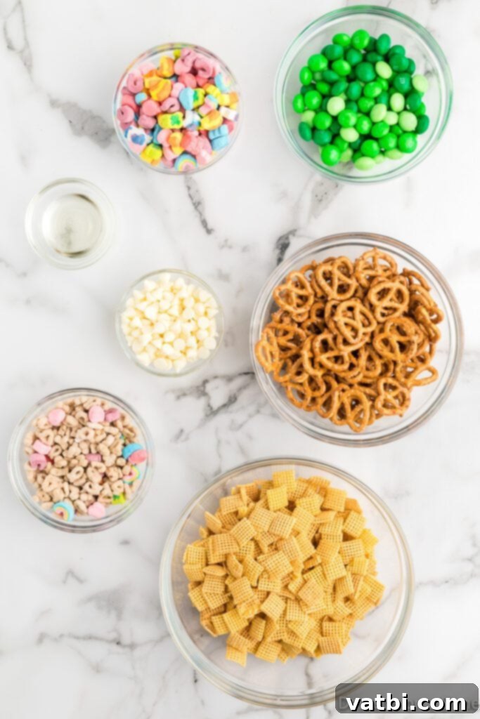 Emerald Enticement 3 Assortment of ingredients for Leprechaun Bait including mini pretzels, Lucky Charms cereal, green M&Ms, white baking chips, and Chex cereal.
