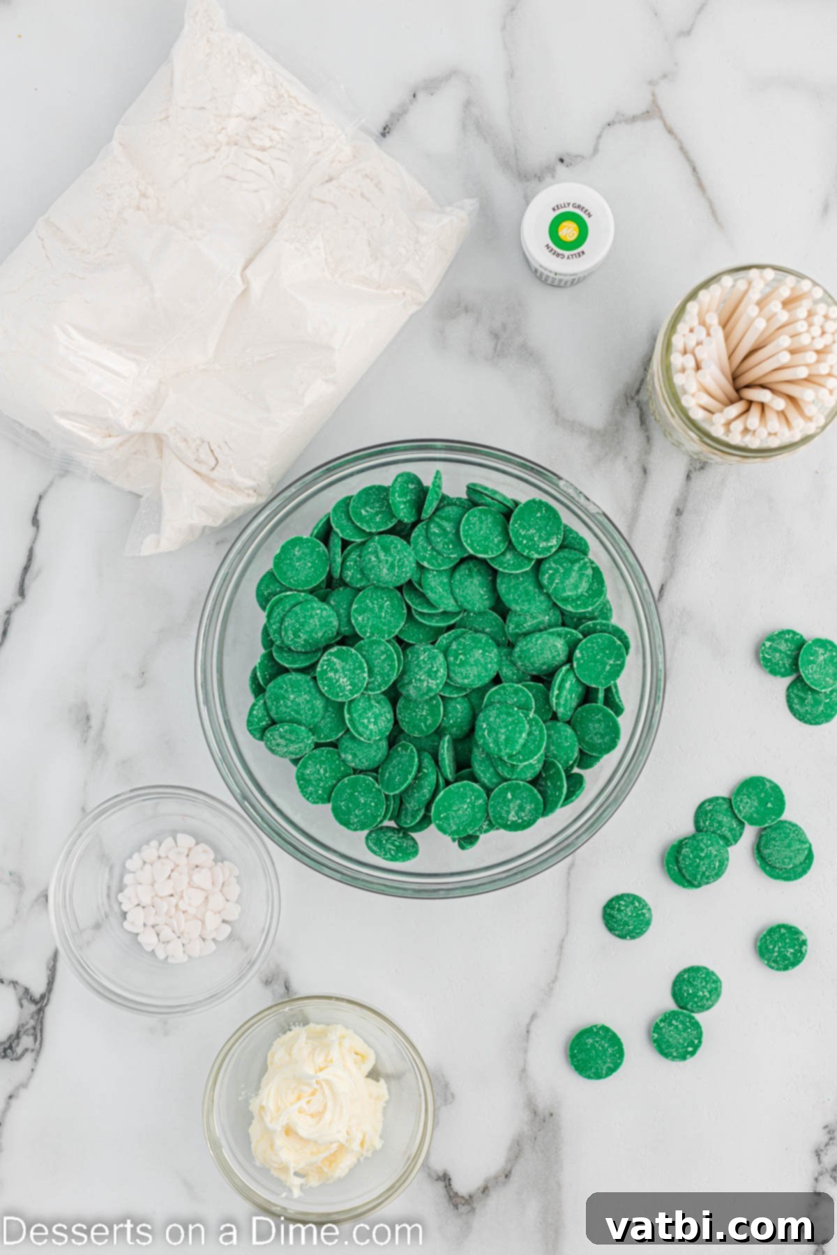 St. Patrick's Day Cake Pops 3 Ingredients needed - boxed cake mix, green food coloring, cream cheese frosting, cake pop sticks, green candy melts, white heart sprinkles
