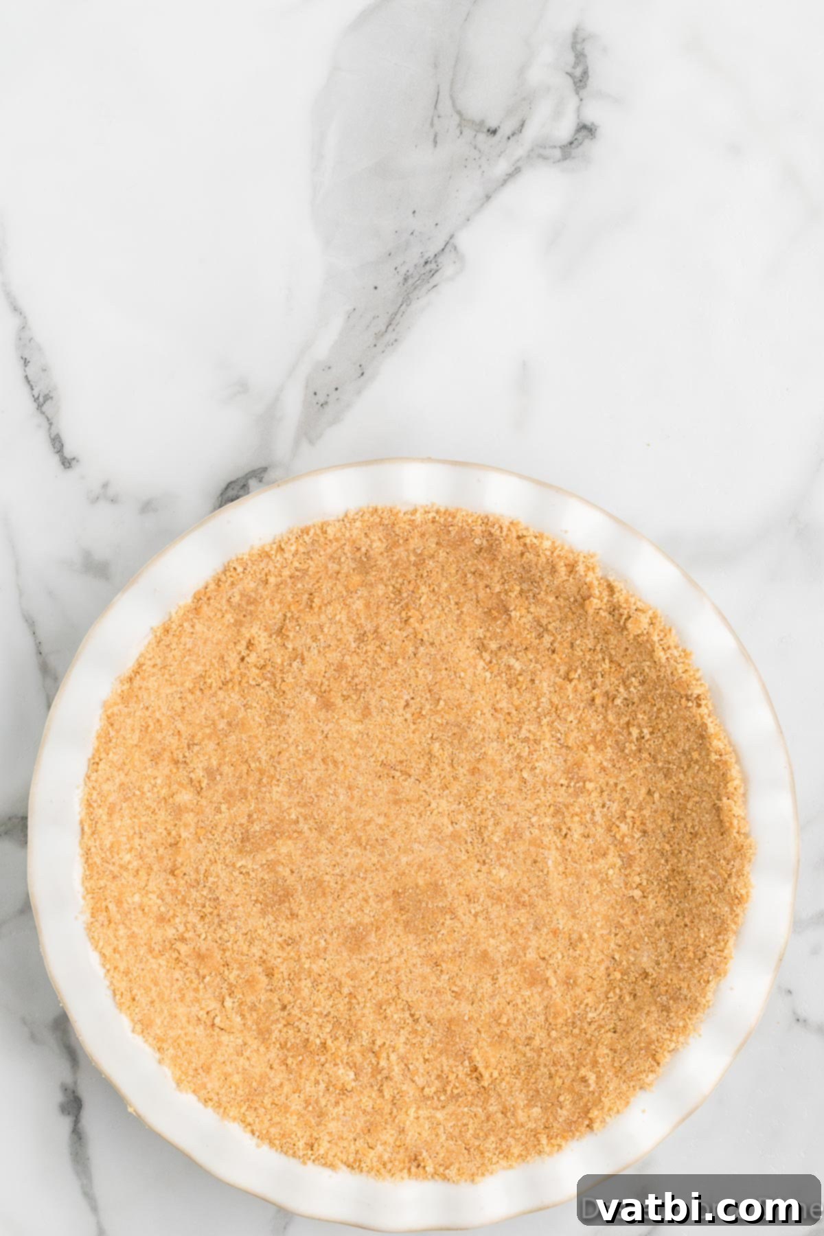 Simple Key Lime Pie Perfection 5 Crust ingredients pressed into a pie plate, ready for baking.