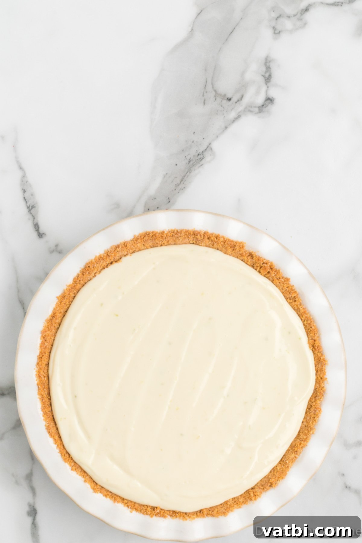 Simple Key Lime Pie Perfection 8 Key lime pie filling poured into the graham cracker crust.