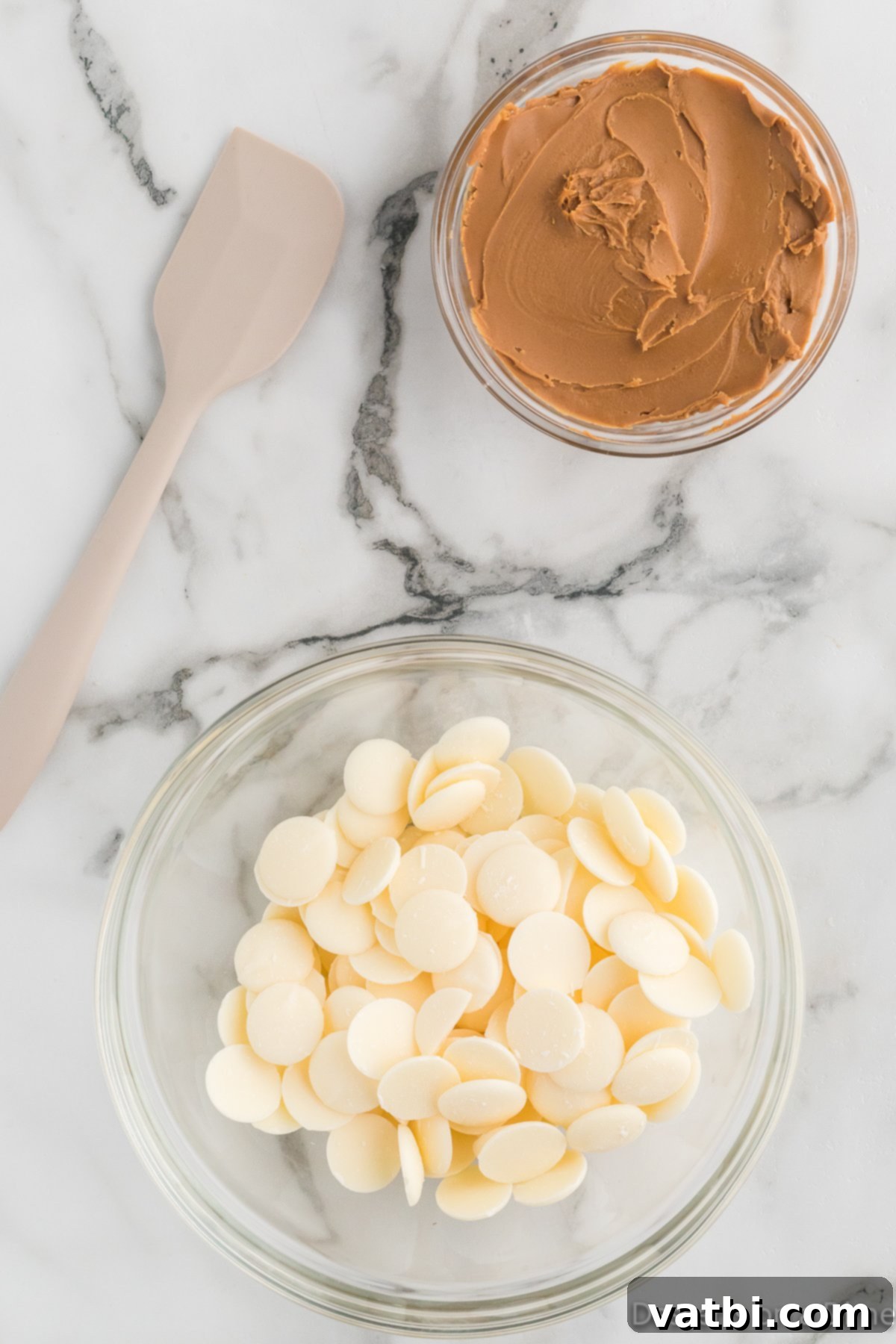 A microwave-safe bowl filled with white melting chocolate wafers, ready to be heated and combined for the popcorn coating.