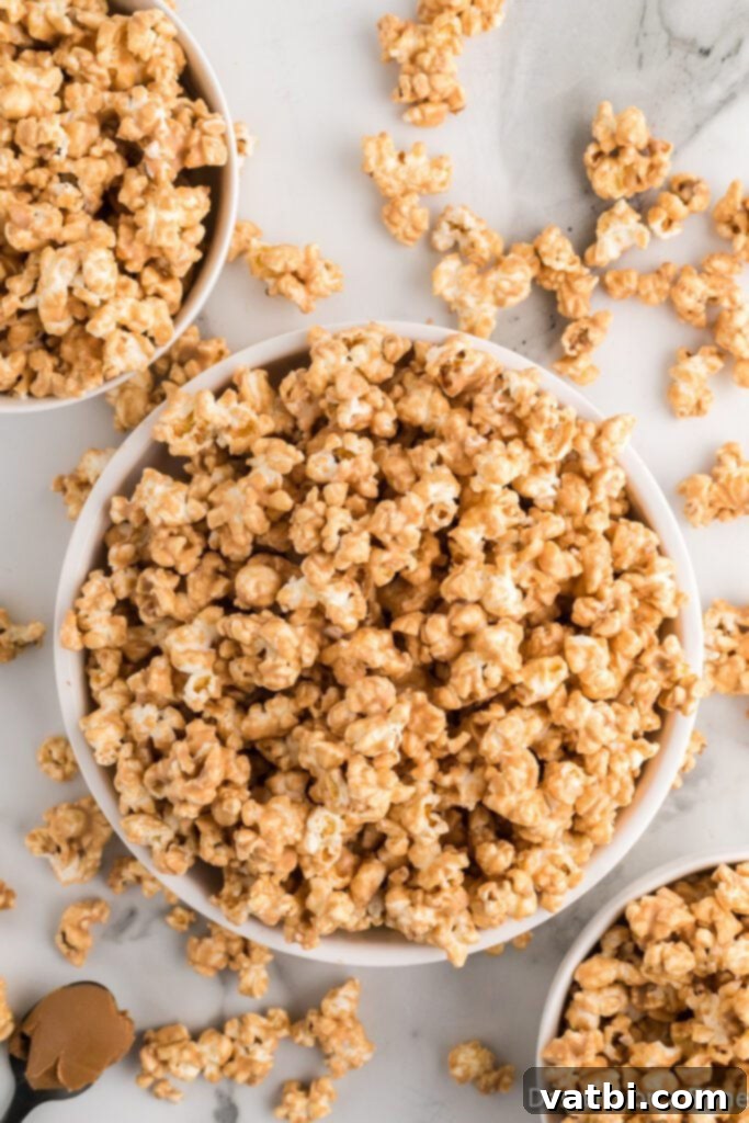 A close-up of a bowl filled with finished Cookie Butter Popcorn, showcasing the crisp, sweet coating on each piece, ready for a sweet and salty snack.