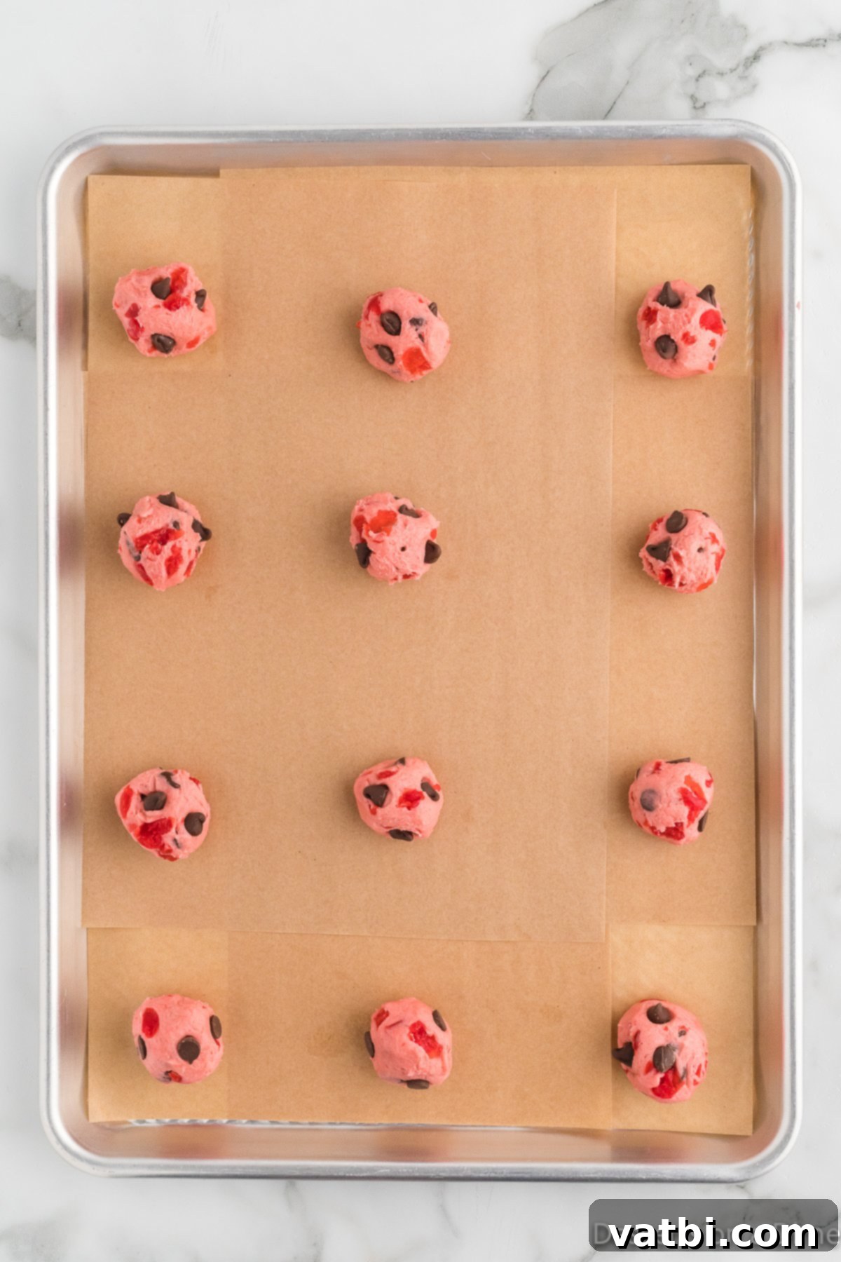 Cookie dough scooped into balls and placed on a baking sheet. 