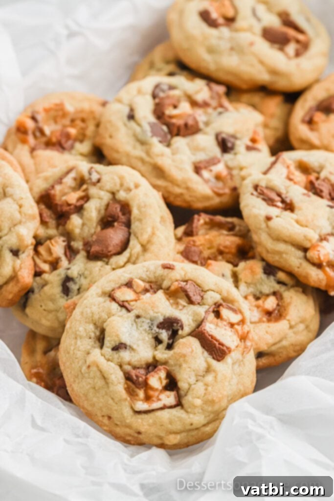 Close-up of stacked Snickers Cookies, showing the melted chocolate and caramel within.