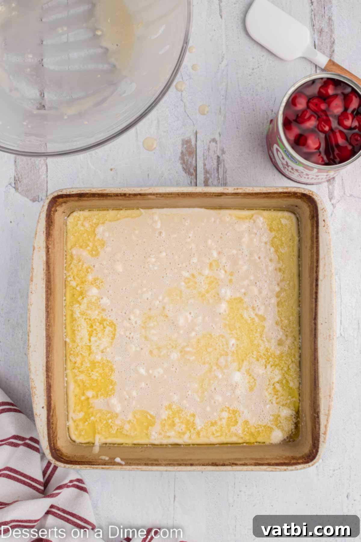 Homemade Cherry Cobbler Bliss 6 Batter poured over melted butter in baking dish.