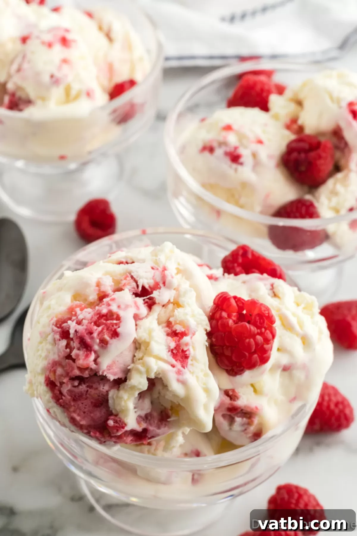 White Chocolate Raspberry Dream 12 White chocolate raspberry ice cream served in bowls with fresh raspberries.