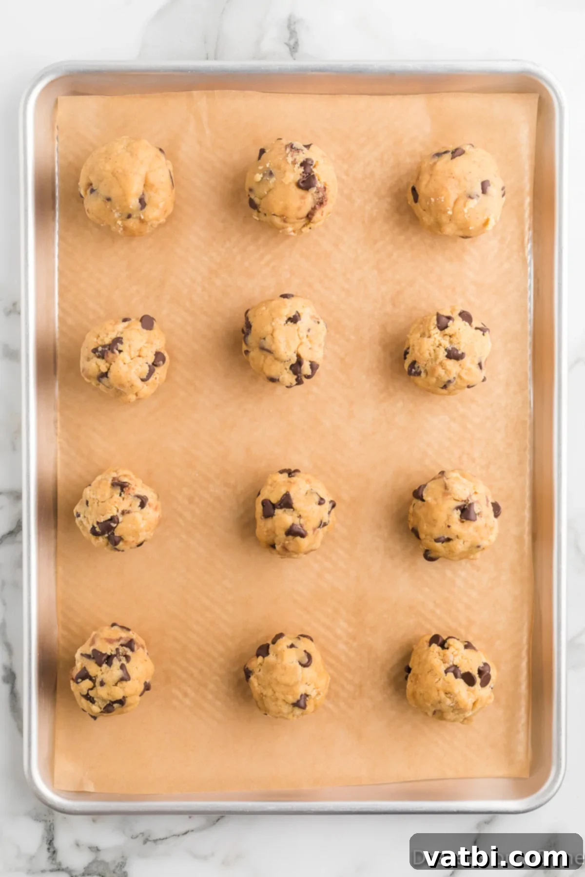 Decadent Nutella Stuffed Cookies 13 Cookie dough being carefully molded and smoothed around the frozen Nutella filling to fully encase it.