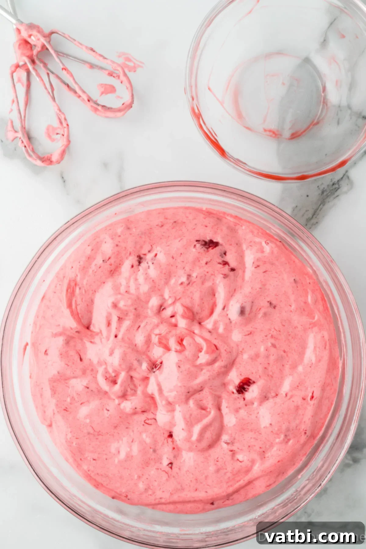 Strawberry Cloud Delight 5 Combined angel food cake mix and strawberry pie filling in a mixing bowl after being mixed.