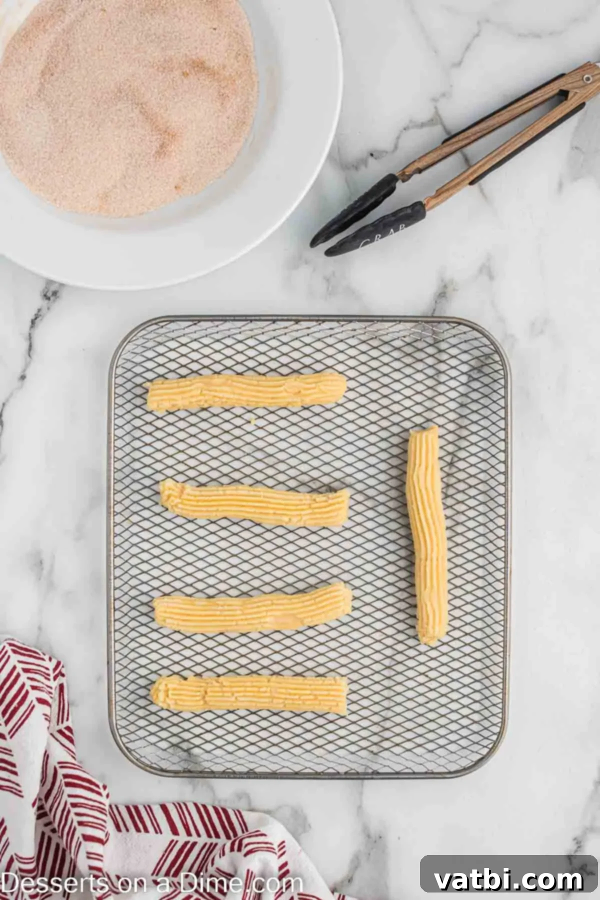 Crispy Air Fryer Churros 9 Frozen churro strips arranged in a single layer in an air fryer basket, ready to be cooked to golden perfection.