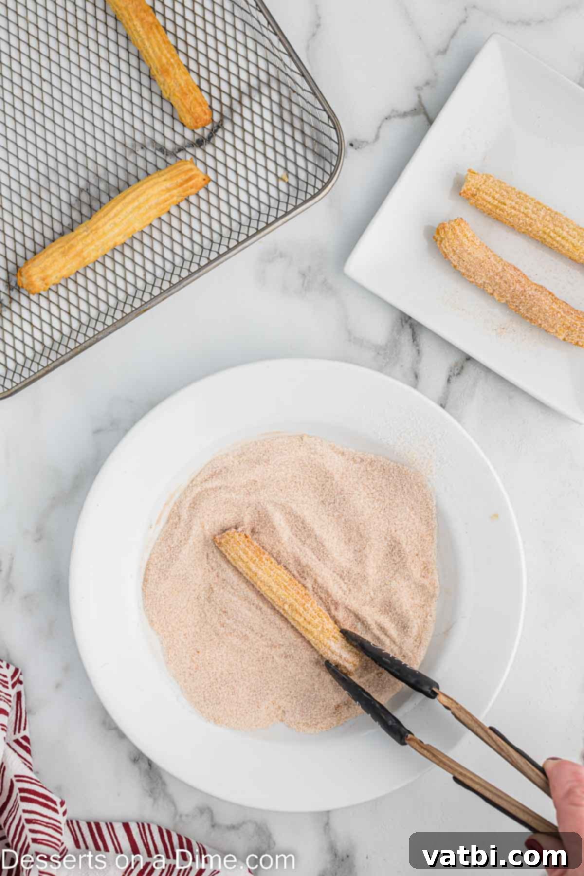 Crispy Air Fryer Churros 10 A freshly air-fried churro being rolled in a bowl of cinnamon and sugar mixture, ensuring an even and delicious coating.