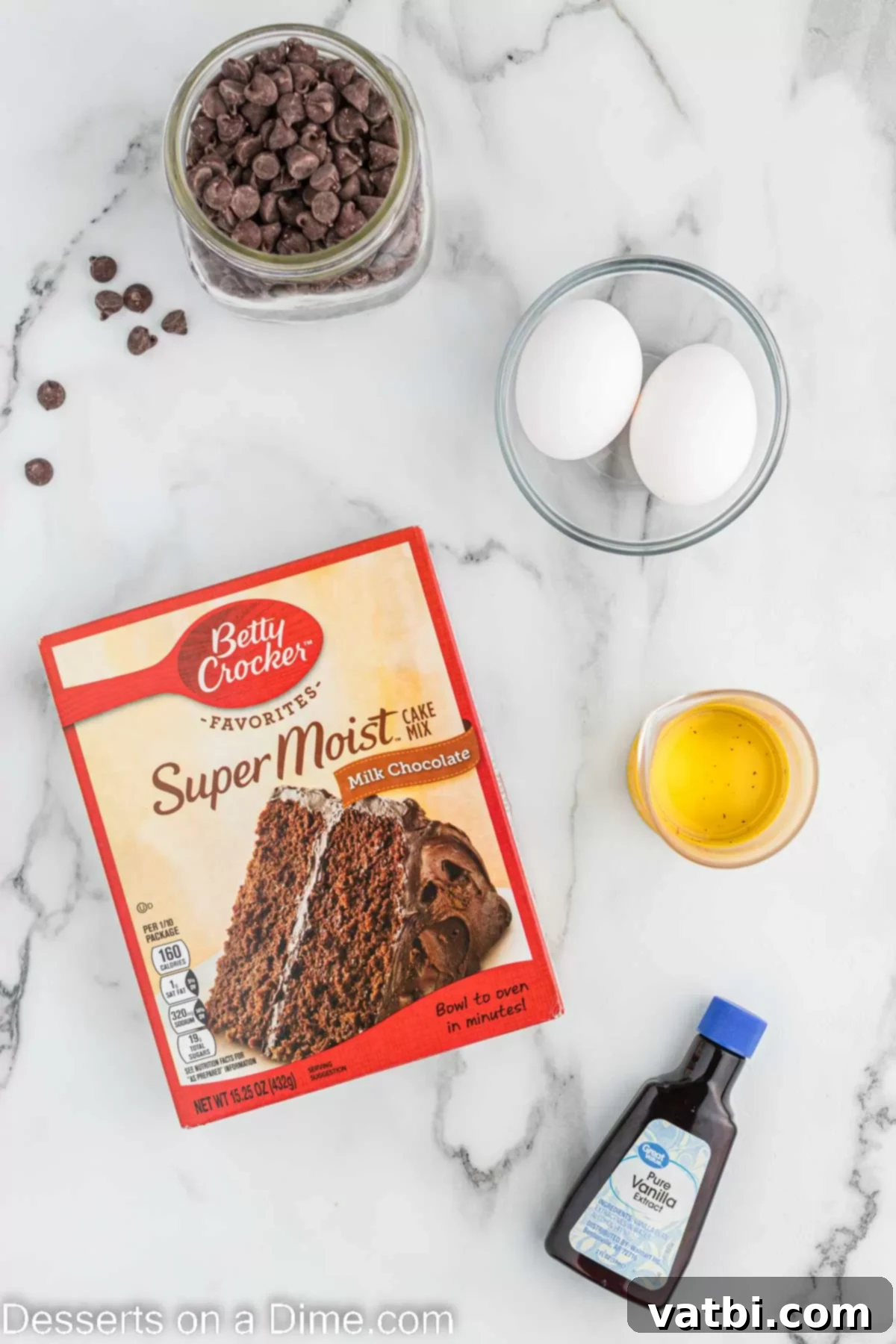 A flat lay photograph displaying the five essential ingredients for cake mix brownies: chocolate cake mix, eggs, vanilla extract, and semi-sweet chocolate chips.
