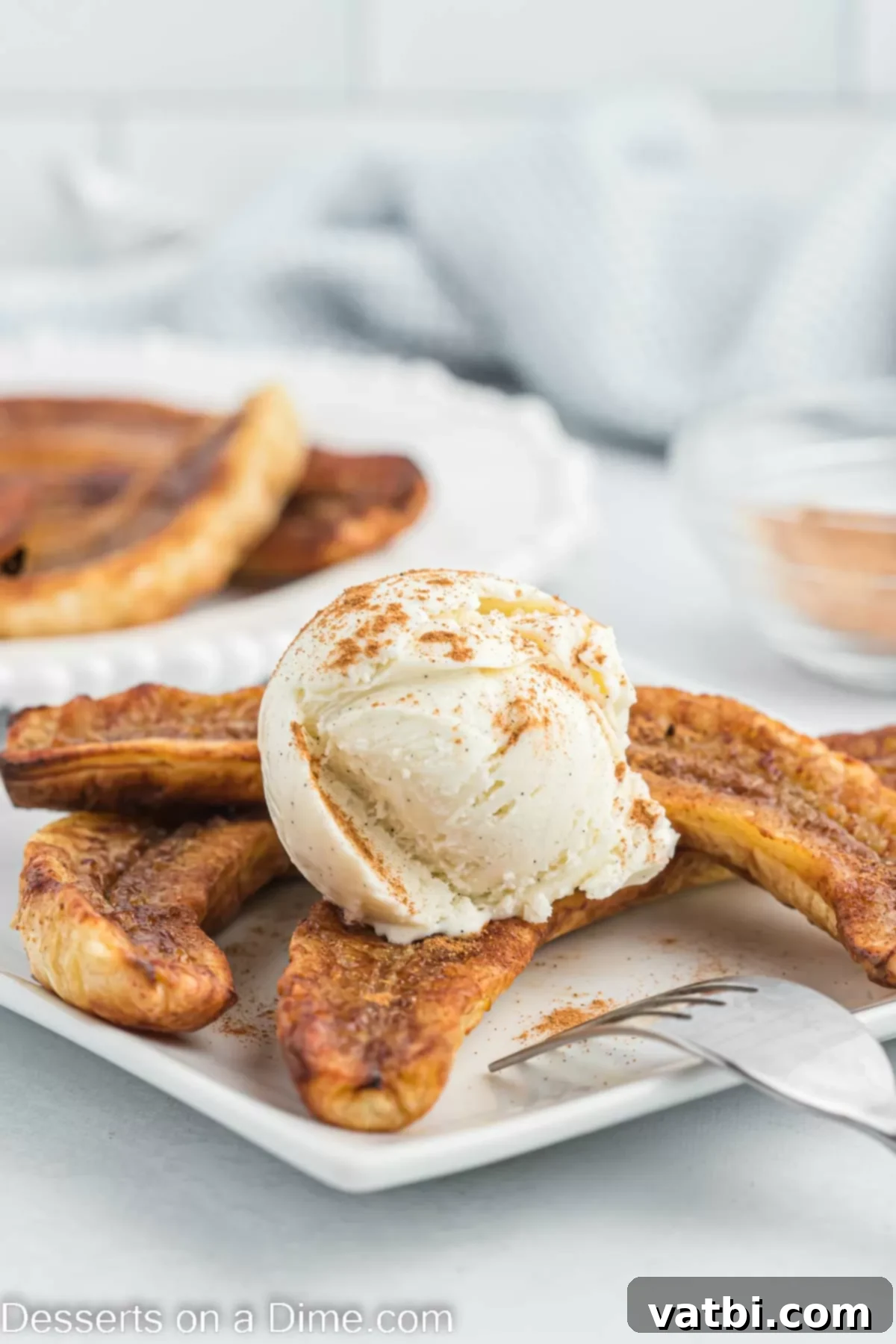 Easy Air Fryer Bananas 2 Air fryer bananas on a plate with a scoop of ice cream