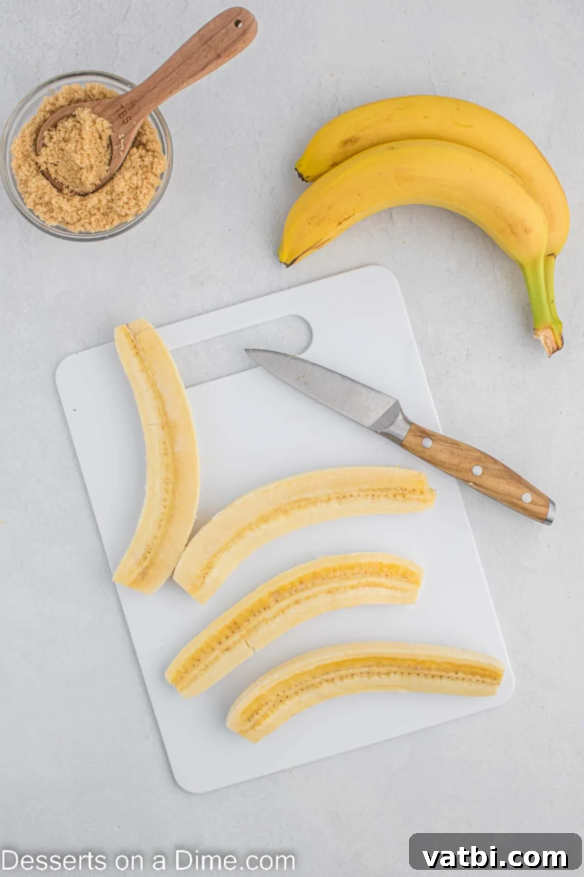 Easy Air Fryer Bananas 5 Bananas sliced on cutting board.