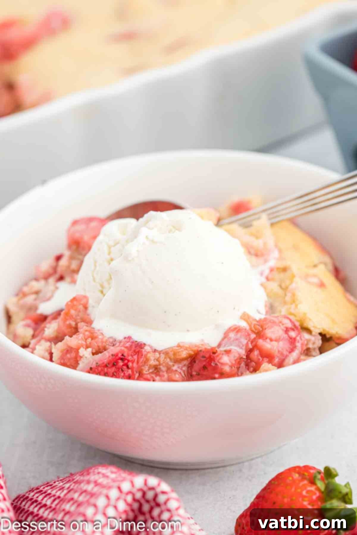Sun-Kissed Strawberry Rhubarb Cobbler 10 A close-up of a warm Strawberry Rhubarb Cobbler in a rustic bowl, generously topped with a dollop of melting vanilla ice cream and a garnish of fresh mint, ready to be enjoyed.