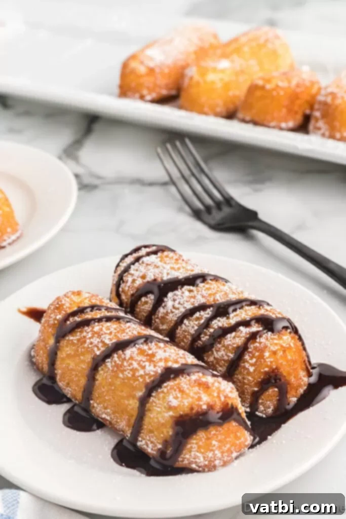 Golden Air Fried Twinkies 2 Fried twinkies on a plate drizzled with chocolate