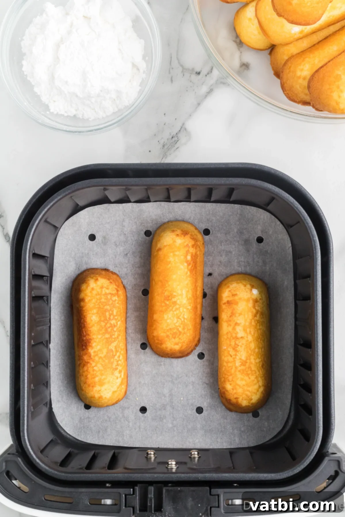 Golden Air Fried Twinkies 5 Twinkies in the air fryer after 1 minute.