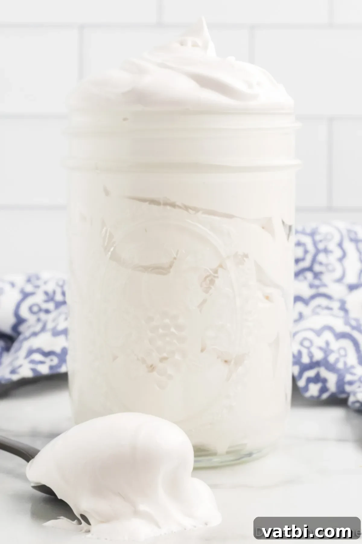 Homemade marshmallow fluff recipe is easy and tastes so much better than store-bought. Try this simple and delicious recipe today! A beautiful jar of freshly made homemade marshmallow fluff, looking light and airy.