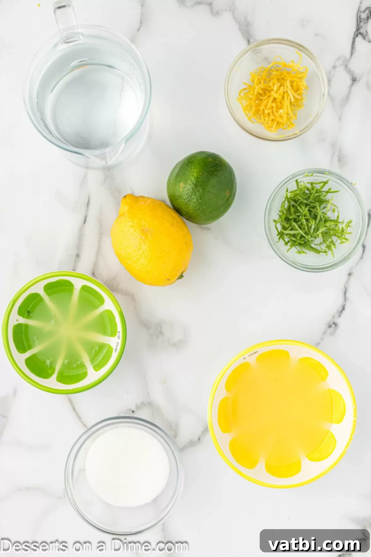 Sunshine Citrus Pops 3 Fresh lemons, limes, and granulated sugar arranged on a surface, ingredients for making lemon lime popsicles.