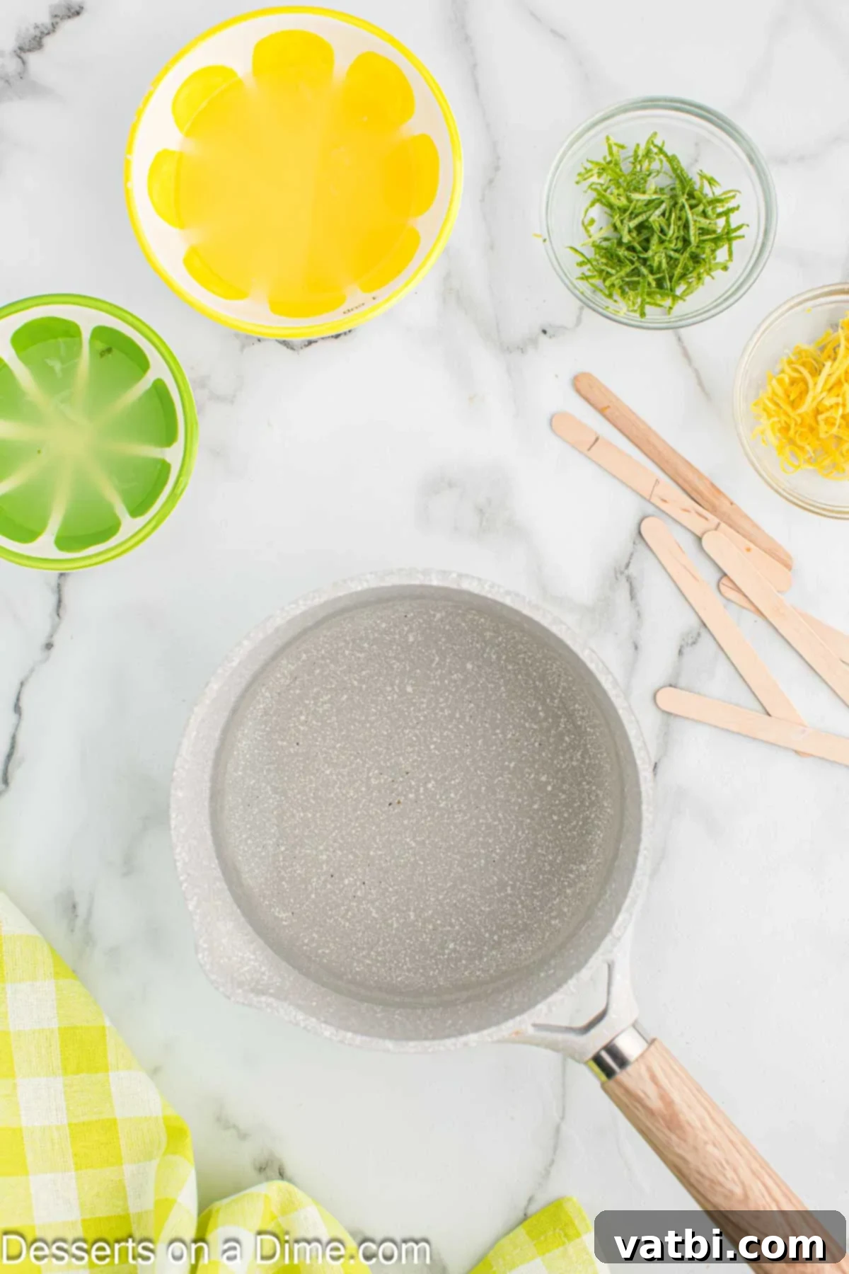Sunshine Citrus Pops 4 Saucepan with water and sugar being whisked over low heat until dissolved.