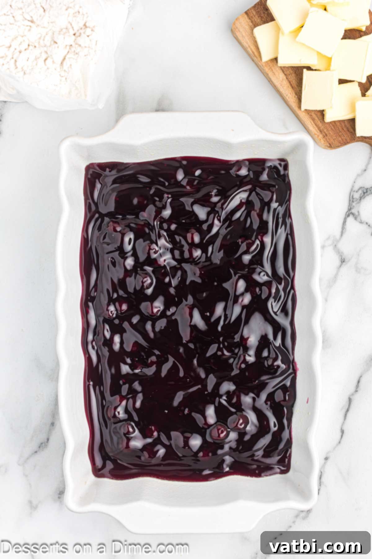 Easy Blueberry Dump Cake 4 Blueberry pie filling in a baking dish.