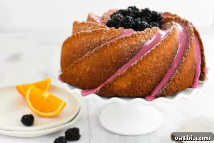 Zesty Delights 15 A beautiful Orange Bundt Cake adorned with fresh blackberries and orange slices, with a vivid purple icing drizzle.