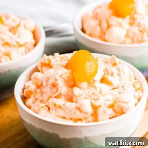 Zesty Delights 6 Three bowls of fluffy Mandarin Orange Jello Salad topped with fresh orange segments.
