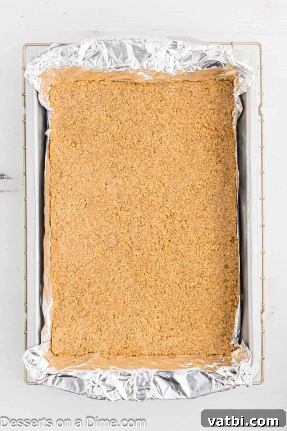 Gooey S'mores Brownie Bliss 4 Graham cracker crust mixture firmly pressed into the prepared baking pan, forming an even base.