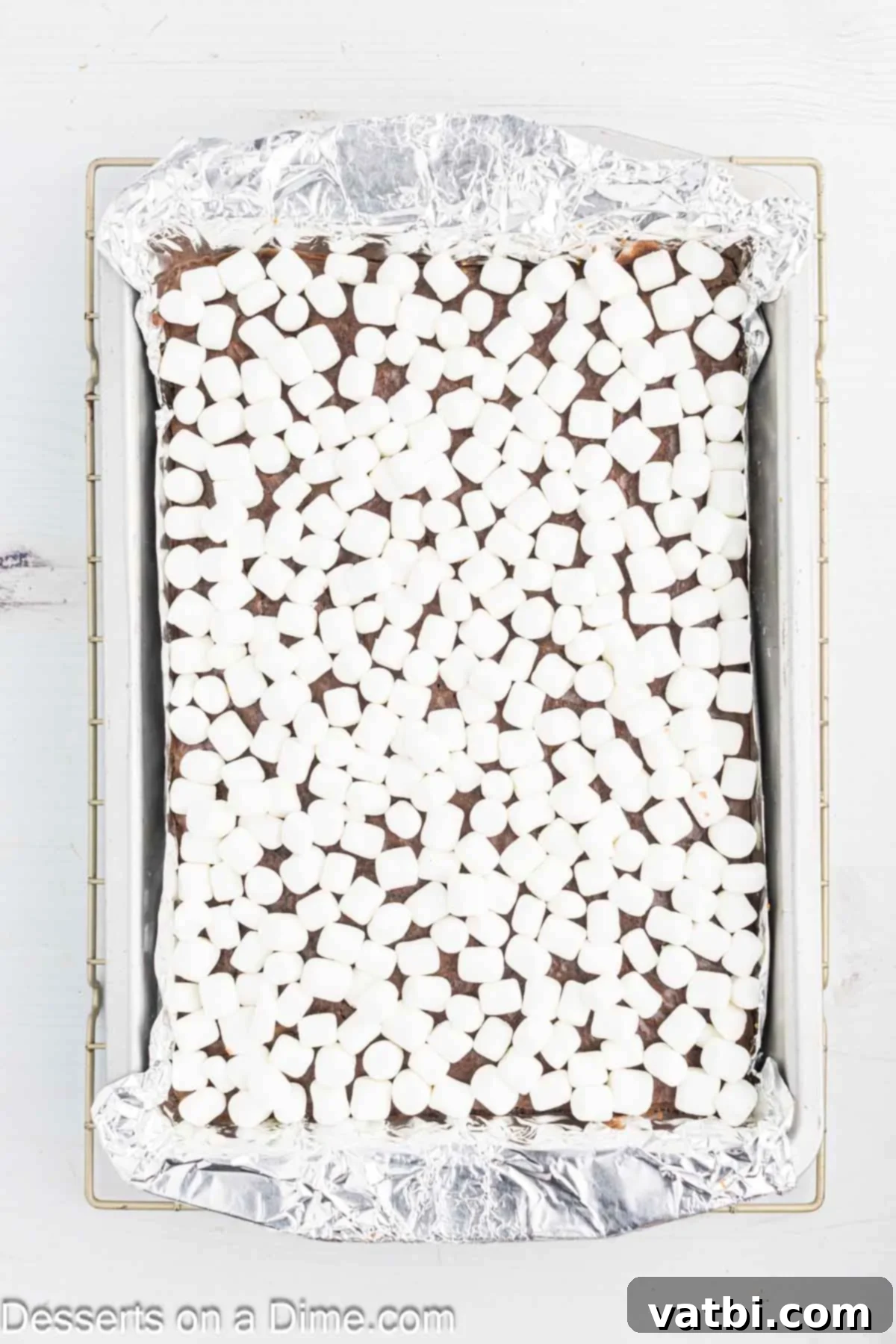 Gooey S'mores Brownie Bliss 7 Mini marshmallows evenly sprinkled over the warm, baked brownies in the pan, ready for broiling.