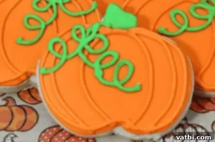 35 Thanksgiving Treats Kids Will Gobble Up 9 Pumpkin Sugar Cookies decorated with fall-themed icing.