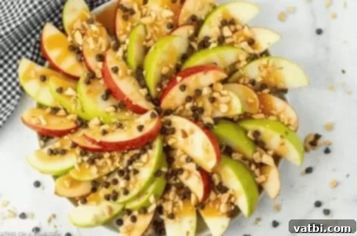 35 Thanksgiving Treats Kids Will Gobble Up 20 Caramel Apple Nachos loaded with toppings on a plate.