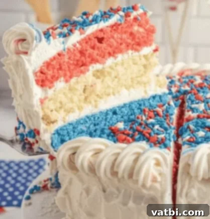 A tall slice of Patriotic Layer Cake with visible red, white, and blue layers.