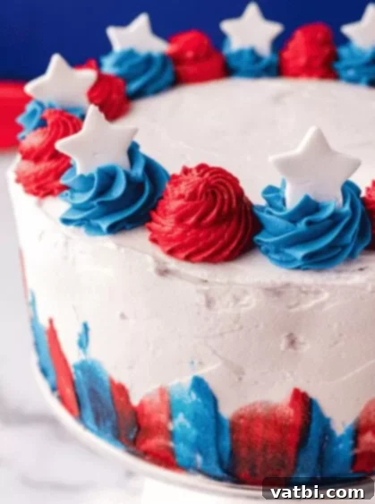 A slice of Jell-O infused 4th of July Cake with red and blue layers.