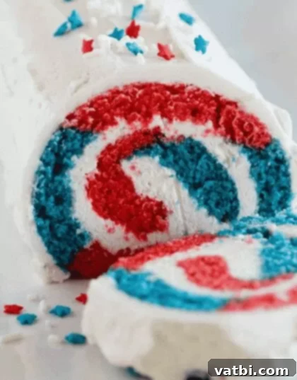 A slice of 4th of July Cake Roll showing the red, white, and blue swirl inside.