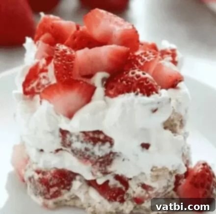 A slice of Strawberry Icebox Cake with whipped cream and fresh strawberries.