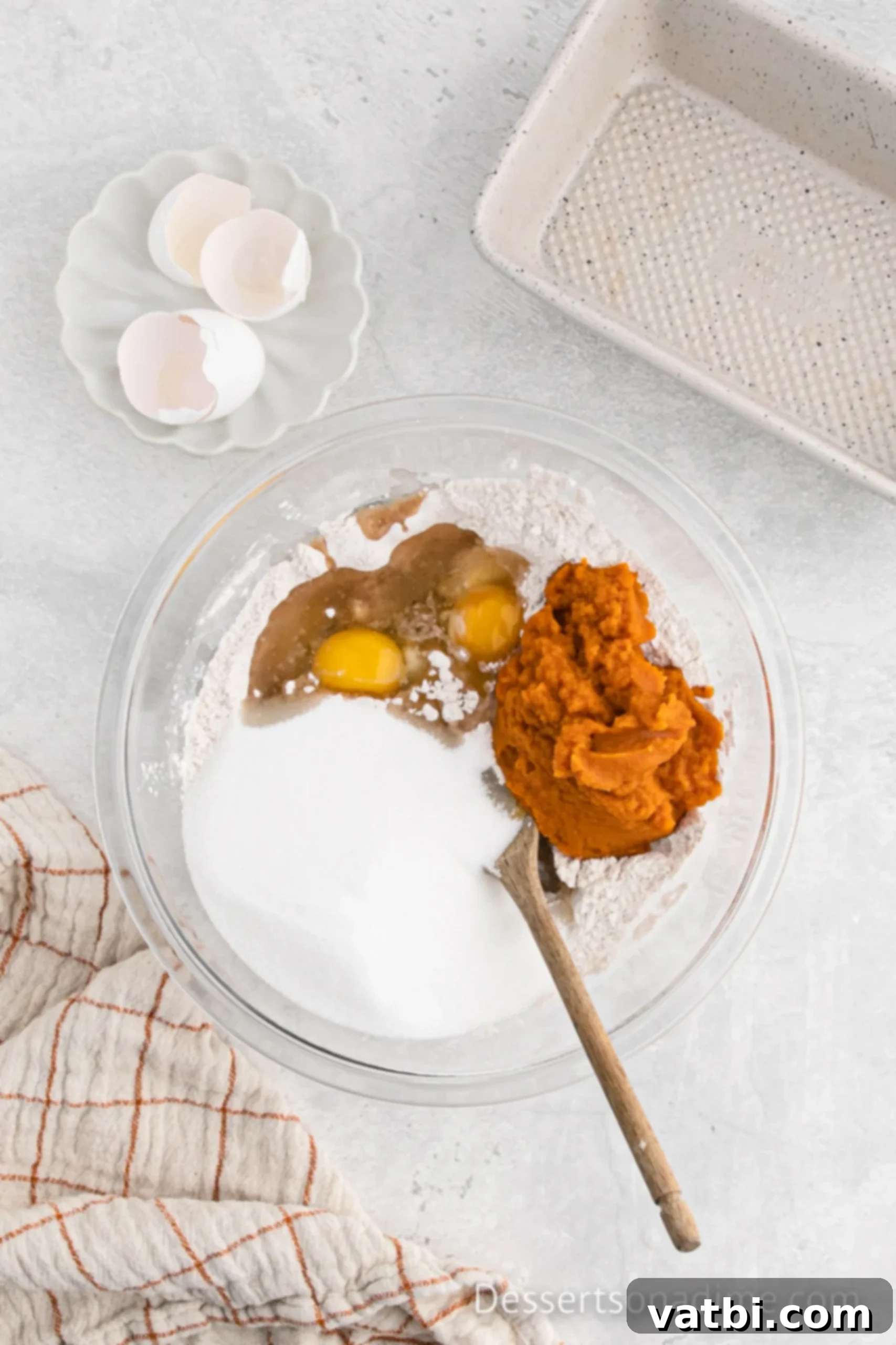 Libby's Pumpkin Bread Recipe 5 Pumpkin puree and eggs being added to the dry ingredients mixture in a bowl.