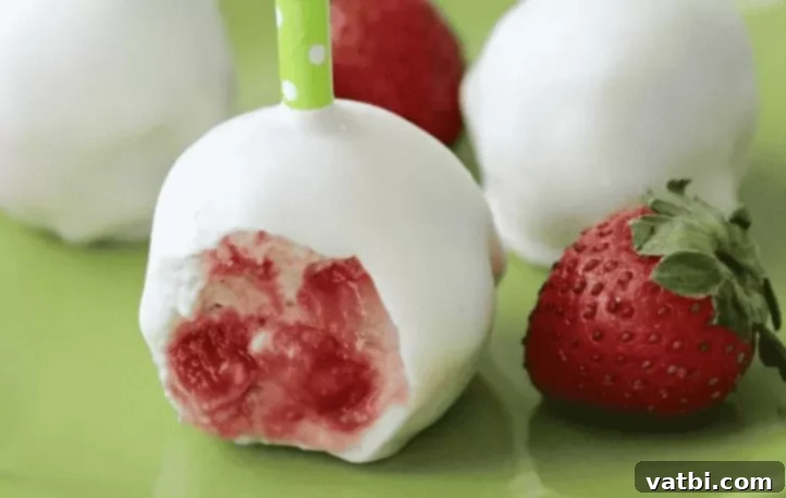 Bite Sized Cake Pop Delights 7 Strawberry Shortcake Cake Pops with white coating and red berry garnishes.