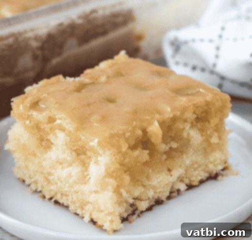31 Sweet Texas Delights 6 A slice of moist vanilla buttermilk cake with a shiny glaze, presented on a white plate.