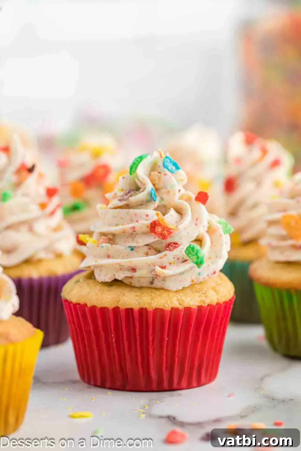 Rainbow Cereal Cupcakes 2 Fruity Pebbles Cupcakes artfully arranged on a colorful serving platter, ready for a party.