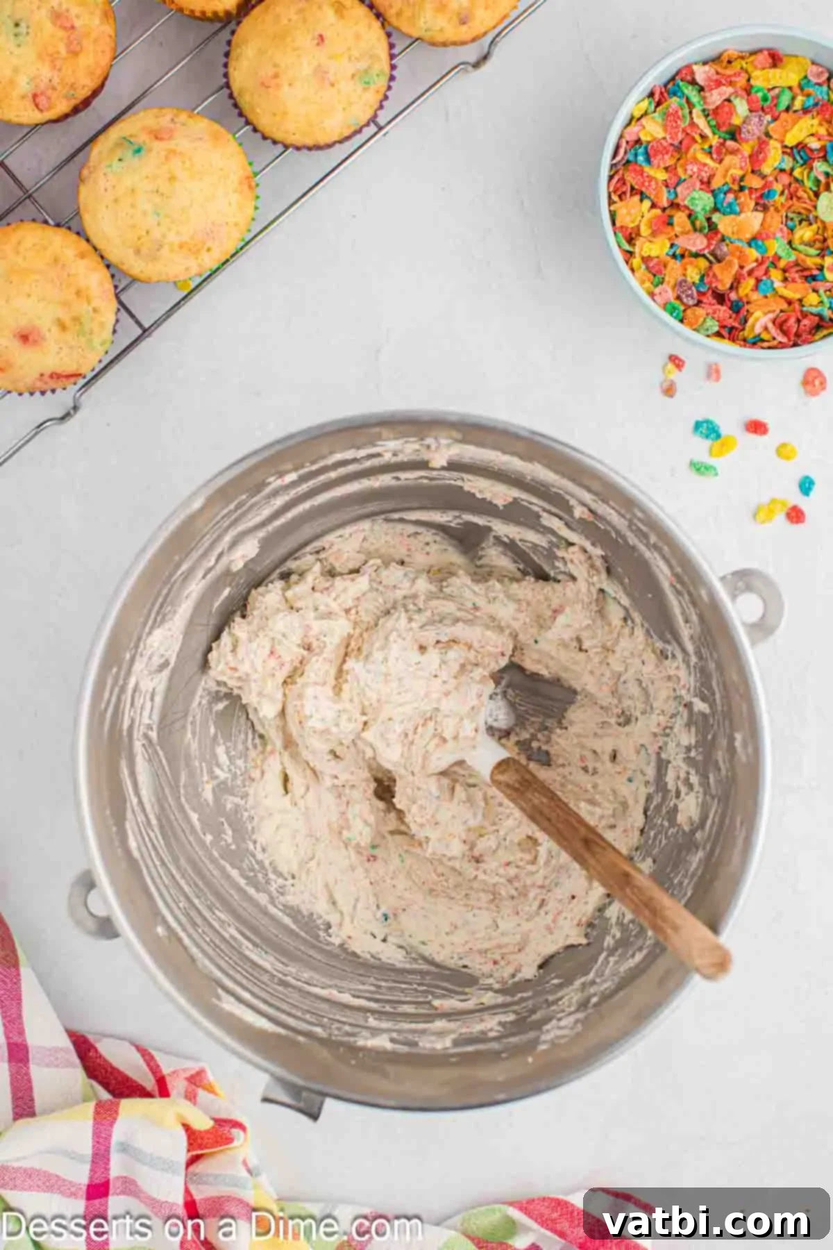 Rainbow Cereal Cupcakes 9 Finely crushed Fruity Pebbles cereal being gently stirred into the fluffy white frosting.