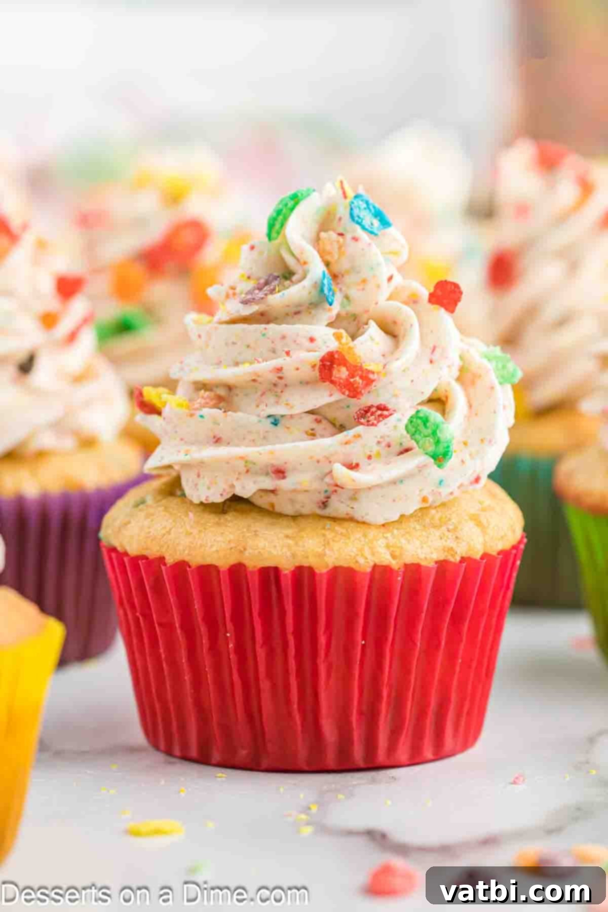 Rainbow Cereal Cupcakes 10 A close-up view of a beautifully frosted Fruity Pebbles cupcake, showcasing the colorful cereal.