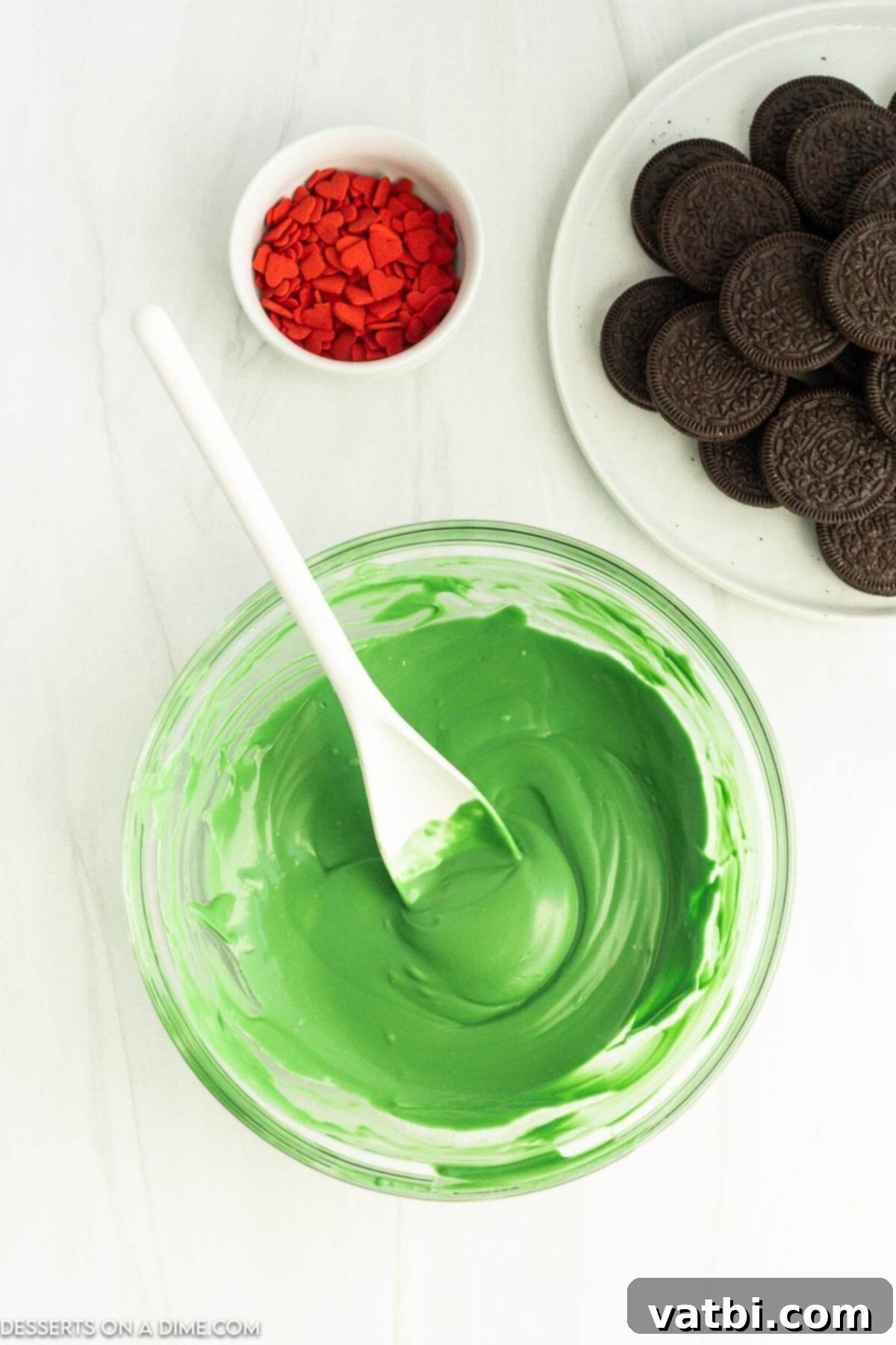 Bowl of melted green candy melts with a spoon.