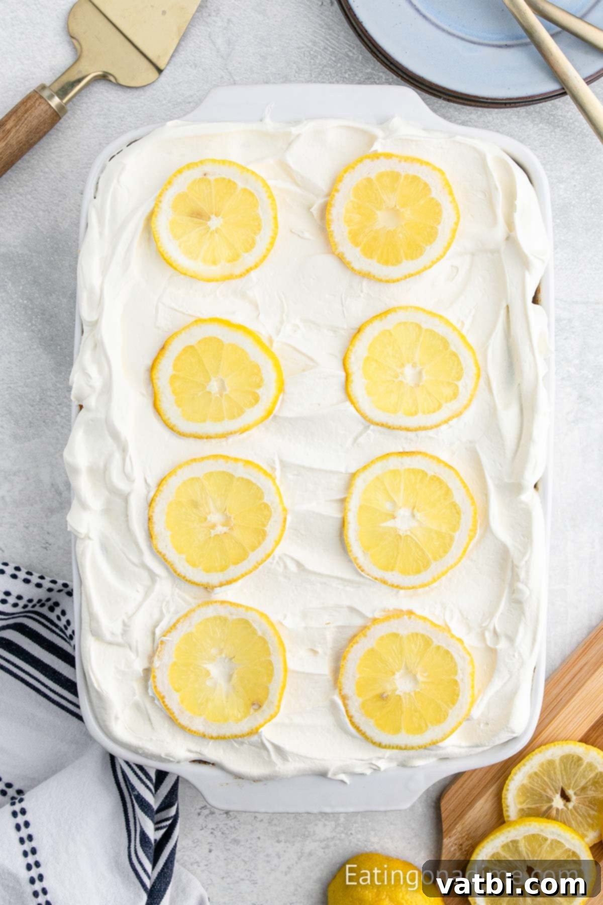 Sunshine Lemon Angel Food Cake 7 Whipped cream spread on cake and topped with lemon slices.