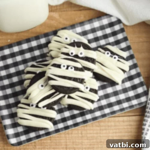 Mummy Oreo Halloween Cookies decorated with white chocolate and candy eyes.