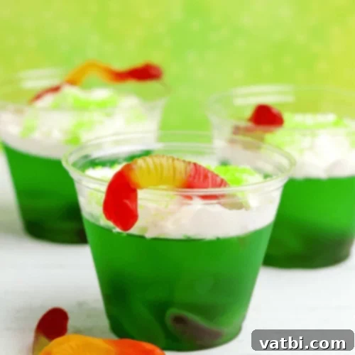 Toxic Waste Halloween Jello Cups with green jello, gummy worms, and foam.