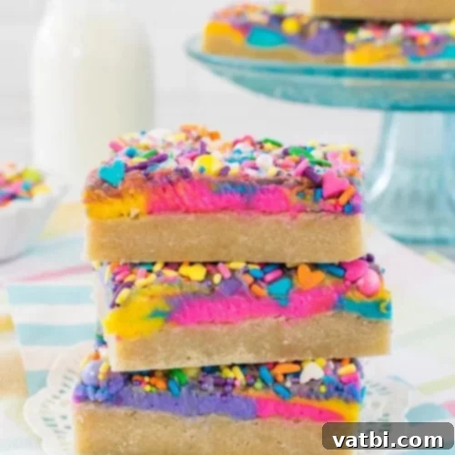 37 Magical Unicorn Desserts 22 Unicorn Sugar Cookie Bars with vanilla sugar cookie, layers of icing, and sprinkles.