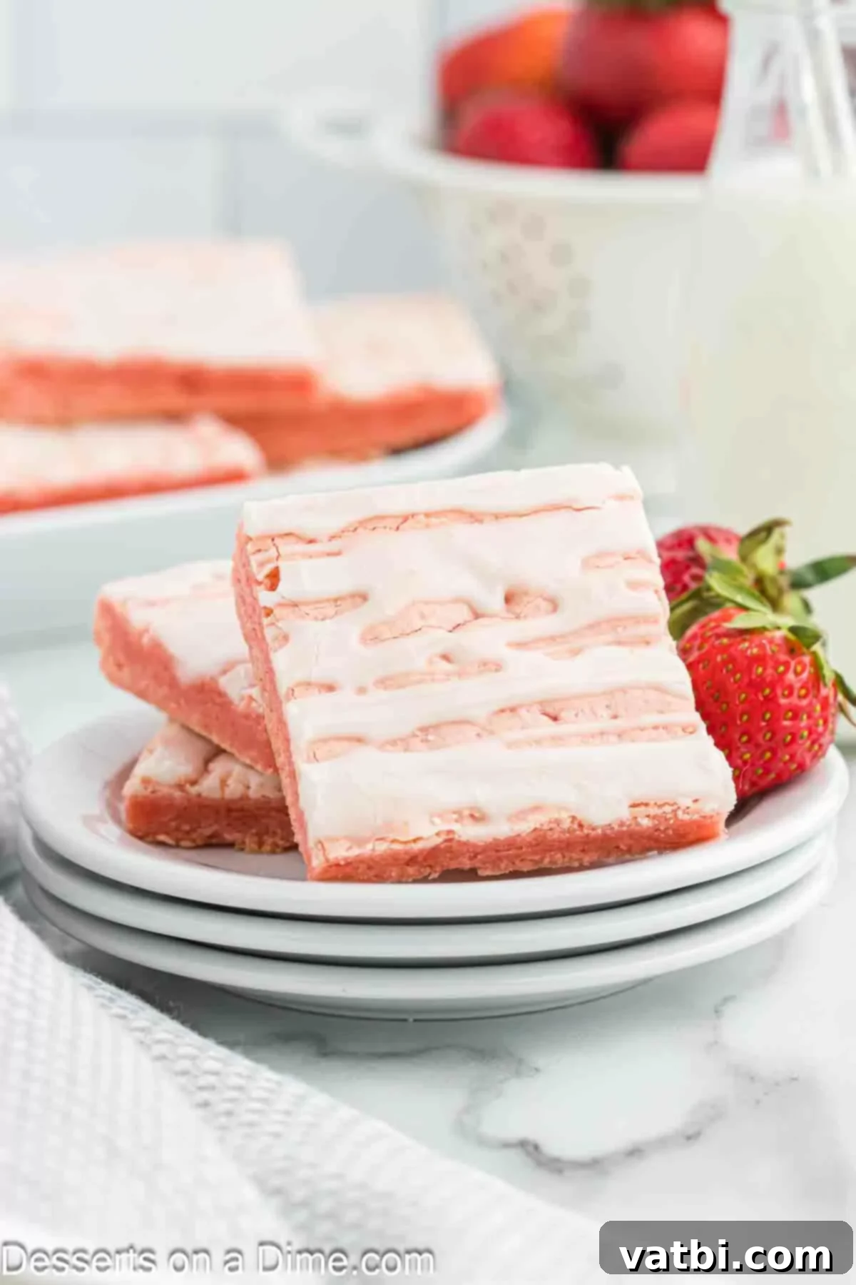 Strawberry Brownies 2 Strawberry brownies cut into squares, showcasing their vibrant pink color and glossy glaze.