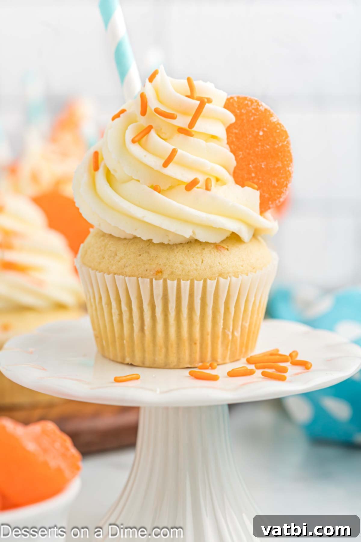 Velvet Orange Dream Cupcakes 2 Freshly baked orange creamsicle cupcake on a white pedestal, ready to be enjoyed.