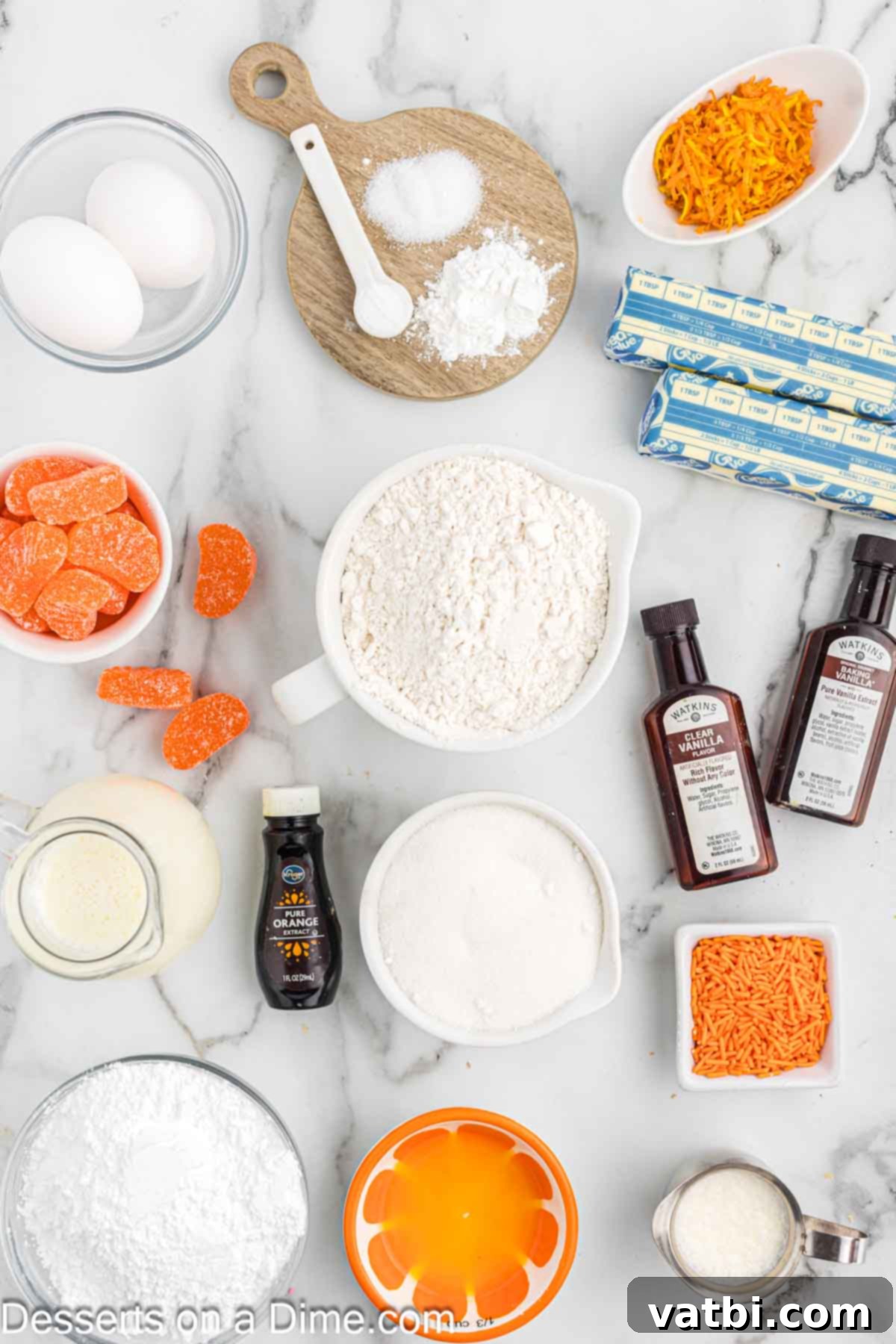 Velvet Orange Dream Cupcakes 3 A collection of ingredients for orange creamsicle cupcakes including flour, baking powder, baking soda, white sugar, eggs, orange zest, orange juice, orange extract, and buttermilk.